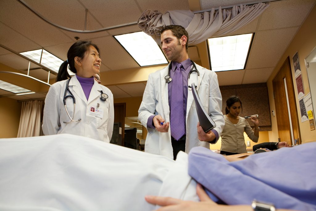 Two doctors at patient's bedside.