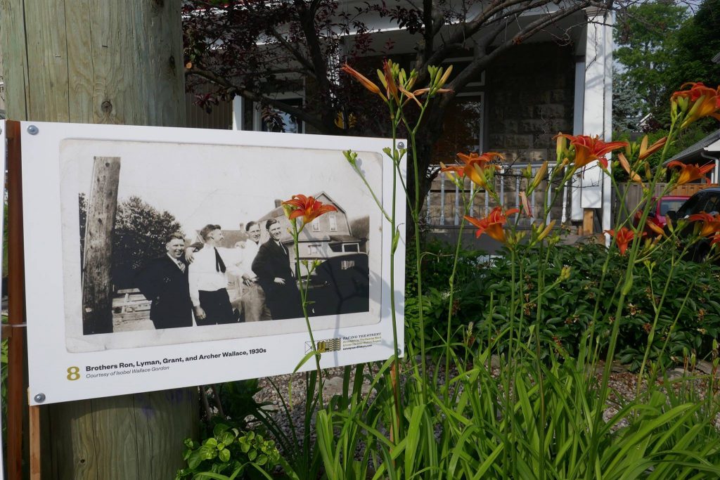 Old photograph of two men, displayed in a garden.