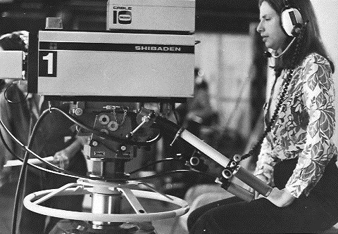 Black and white photo of woman using a camera.